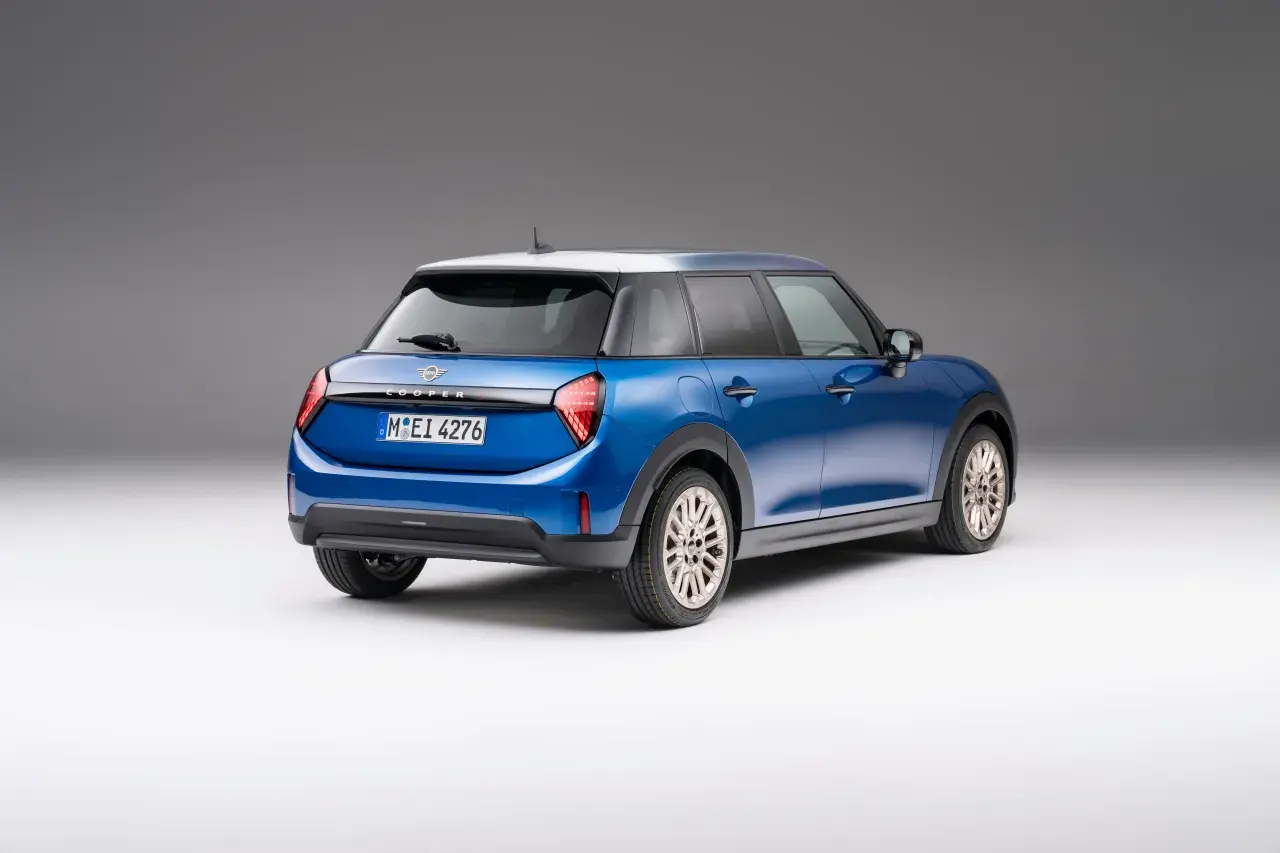 Niebieski Mini Cooper z białym dachem, widok z tyłu. Sprawdź aktualną mini cooper cena i dostępne wersje.