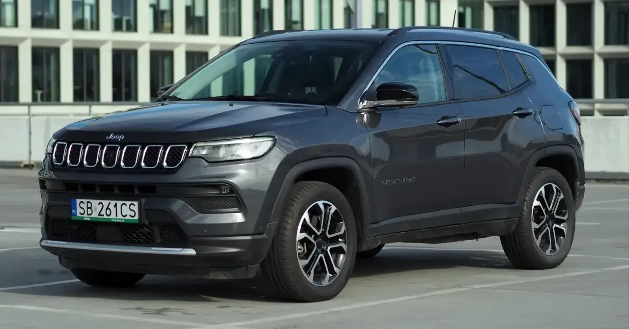 Szary Jeep Compass na parkingu. Wiele osób szuka jeep compass opinie przed zakupem.