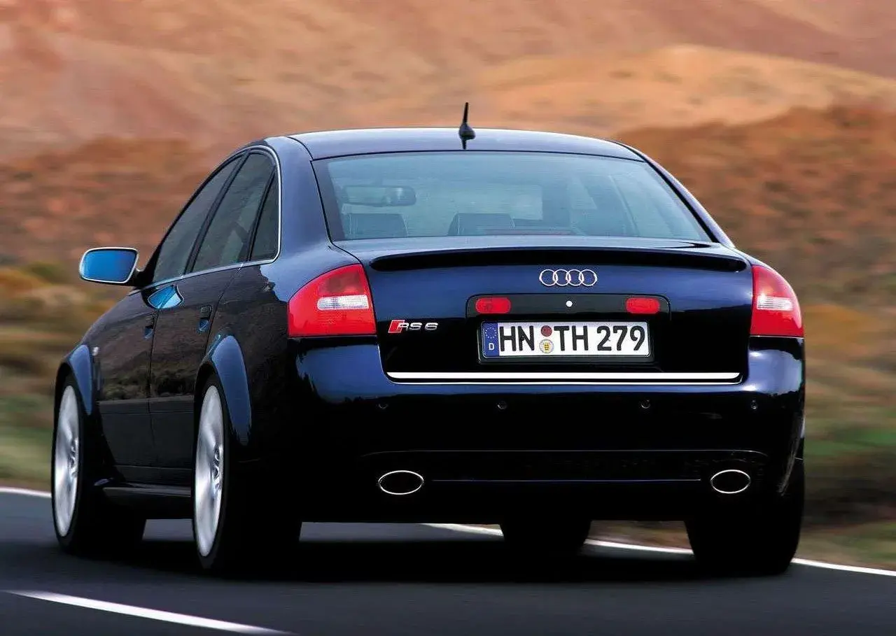 Ciemnoniebieskie Audi RS6 C5 z tablicą rejestracyjną HN TH 279 jedzie po drodze.