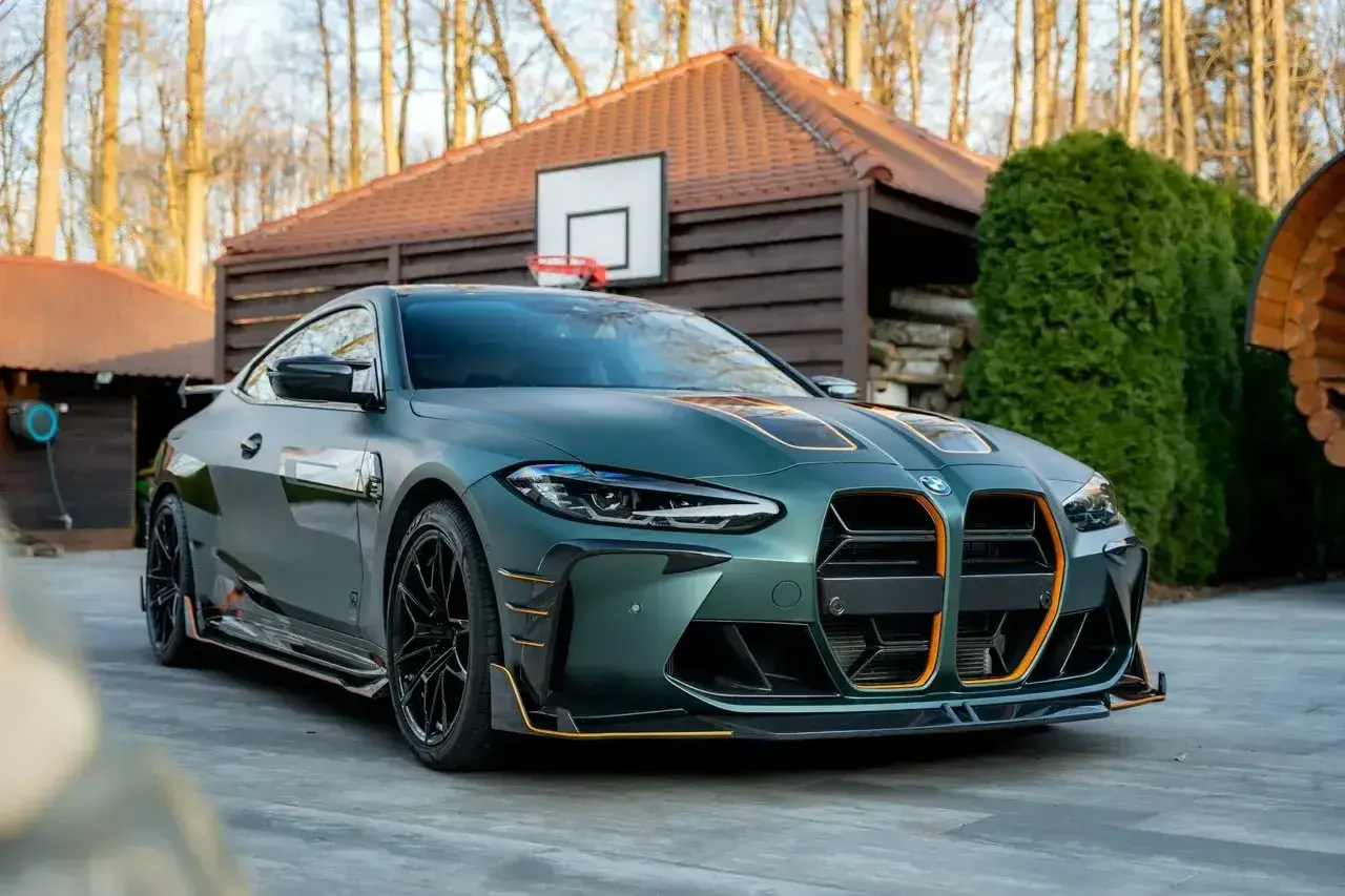 Sportowy BMW M4 w zielonym matowym kolorze z pomarańczowymi akcentami. Sprawdź aktualną bmw m4 cena!