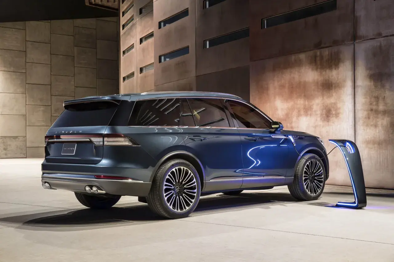 Elegancki, niebieski Lincoln Aviator ładowany przy futurystycznej stacji. Nowoczesność i moc w jednym.
