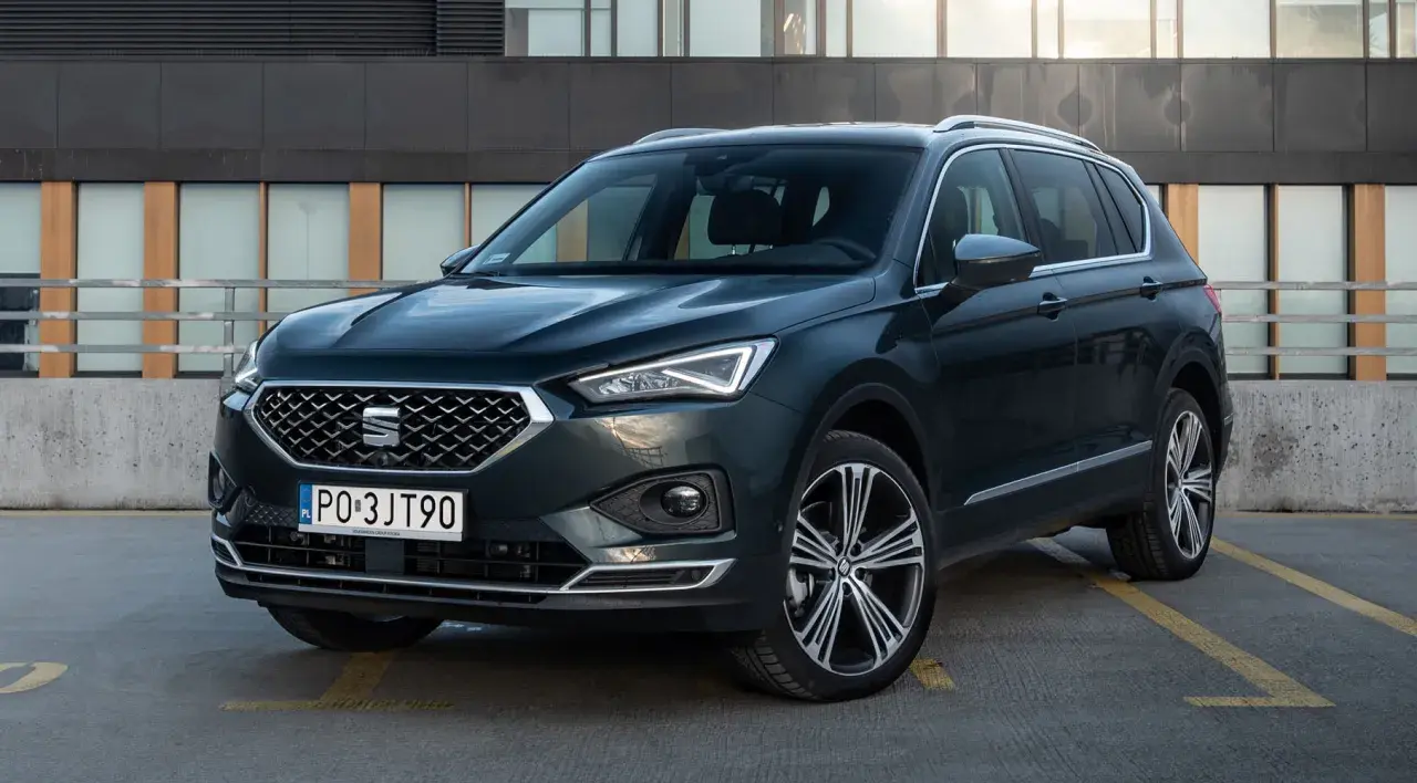 Ciemnozielony SUV z dużym bagażnikiem, zaparkowany na zewnątrz.