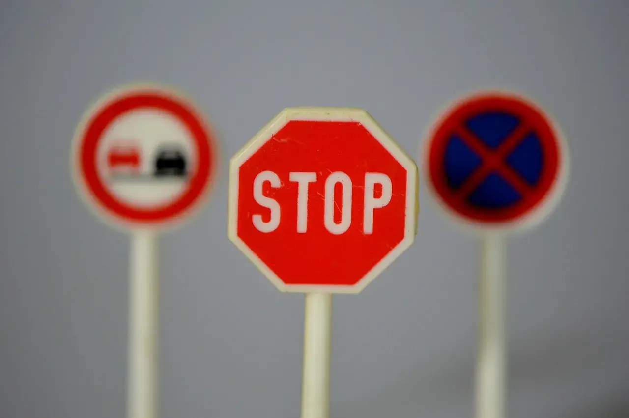 Trzy miniaturowe znaki drogowe: STOP, zakaz wyprzedzania i zakaz zatrzymywania się. Idealne do nauki przepisów ruchu drogowego.