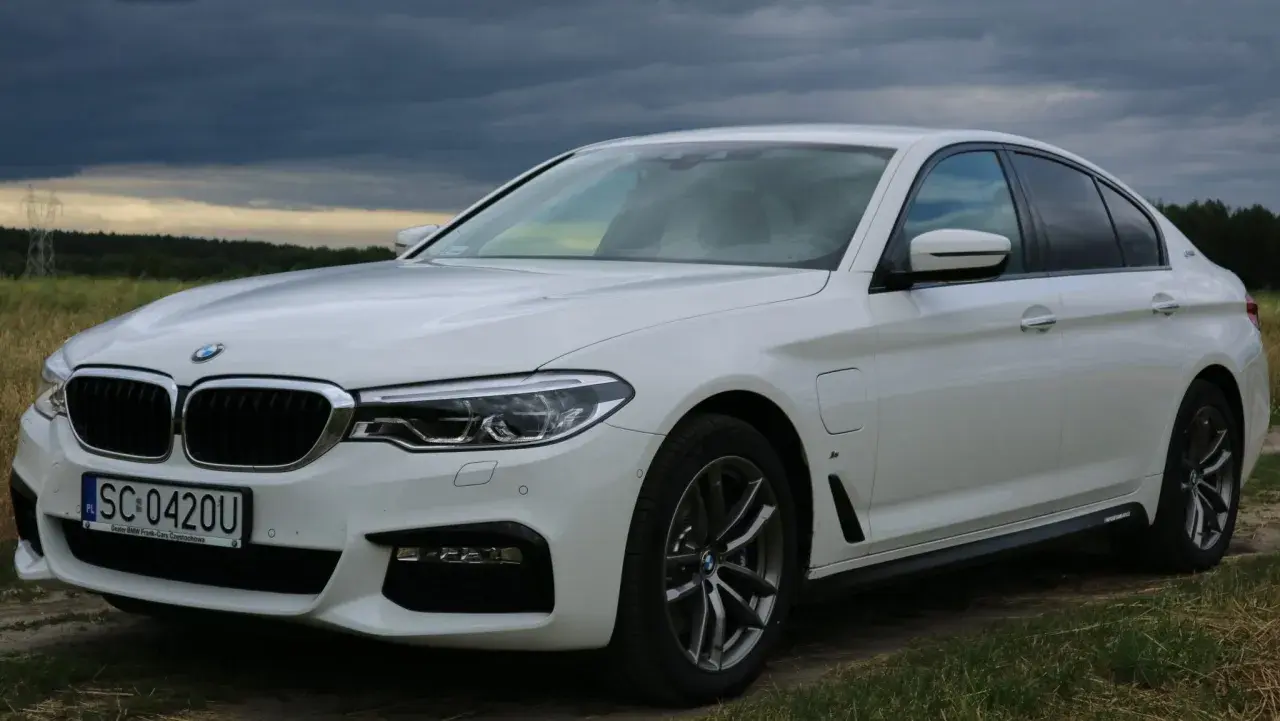 Białe BMW 530 na tle burzowego nieba. Elegancka limuzyna z polskimi tablicami rejestracyjnymi SC 0420U.