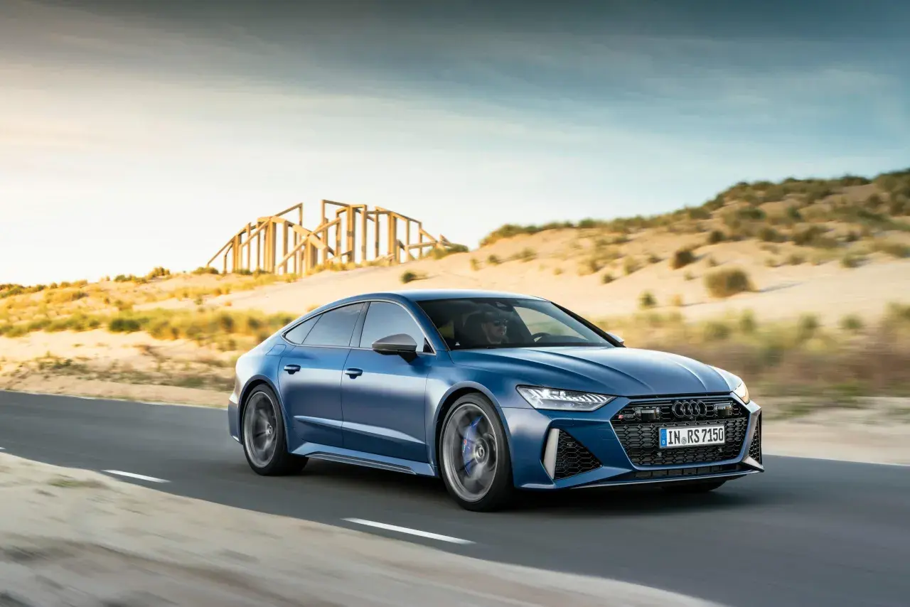 Niebieskie Audi RS7 mknie po pustynnej drodze. Sprawdź aktualną audi rs7 cena i poczuj moc!
