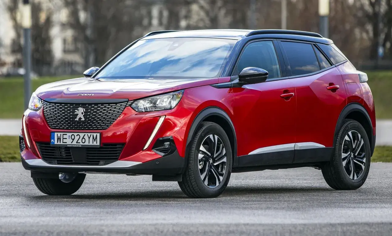 Czerwony Peugeot 2008 na zewnątrz. Wiele osób szuka peugeot 2008 opinie, by dowiedzieć się więcej o tym modelu.
