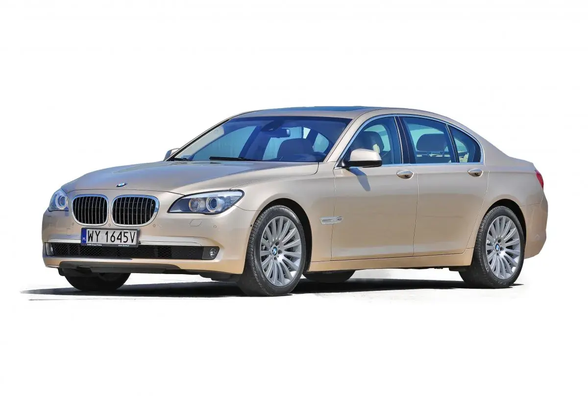 Eleganckie, beżowe BMW 7 F01 z przyciemnianymi szybami i chromowanymi detalami, prezentujące się na białym tle.