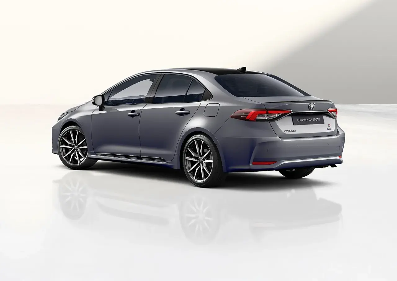 Szary sedan Toyota Corolla GR Sport z czarnym dachem i sportowymi felgami, prezentujący dynamiczną sylwetkę.