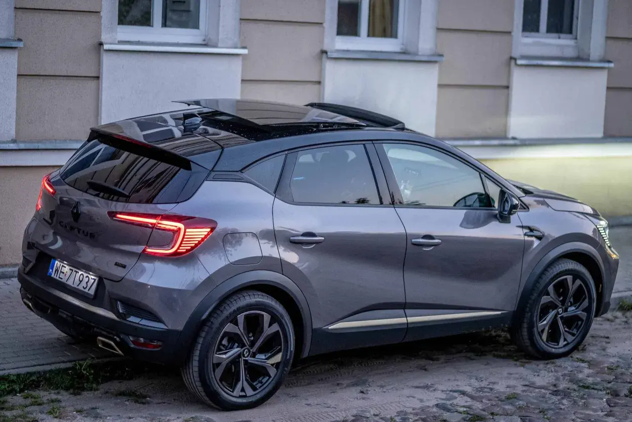 Szary Renault Captur z czarnym dachem i panoramicznym szyberdachem, idealny do miasta. Wiele pozytywnych renault captur opinie potwierdza jego wszechstronność.