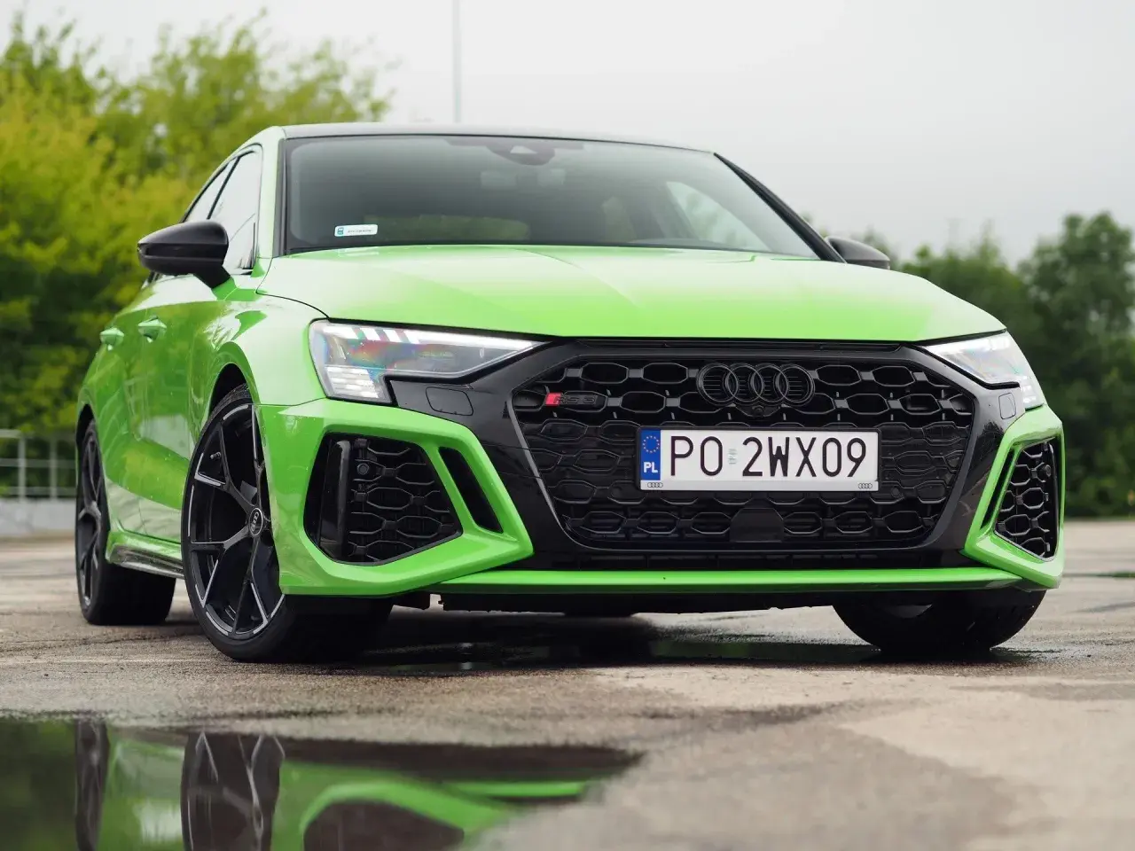 Jaskrawozielone Audi RS3 z czarnymi felgami i grillem. Sprawdź aktualną audi rs3 cena i dostępne opcje.