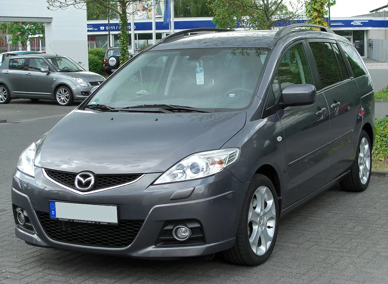 Szary minivan Mazda 5 na parkingu. Wiele osób szuka mazda 5 opinie, ten model jest dobrym wyborem.