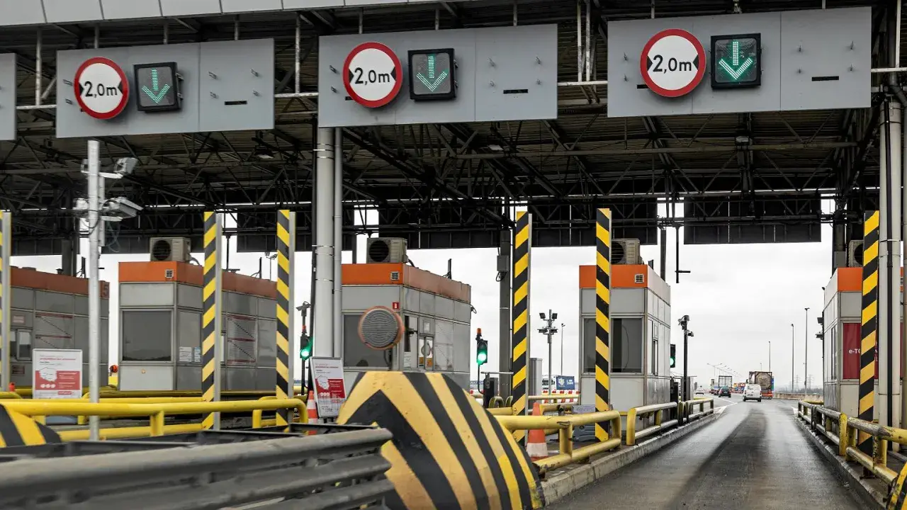 Płatne autostrady w Polsce: szlabany na bramkach poboru opłat, znaki ograniczenia wysokości 2,0m i zielone strzałki wskazujące otwarte pasy ruchu.