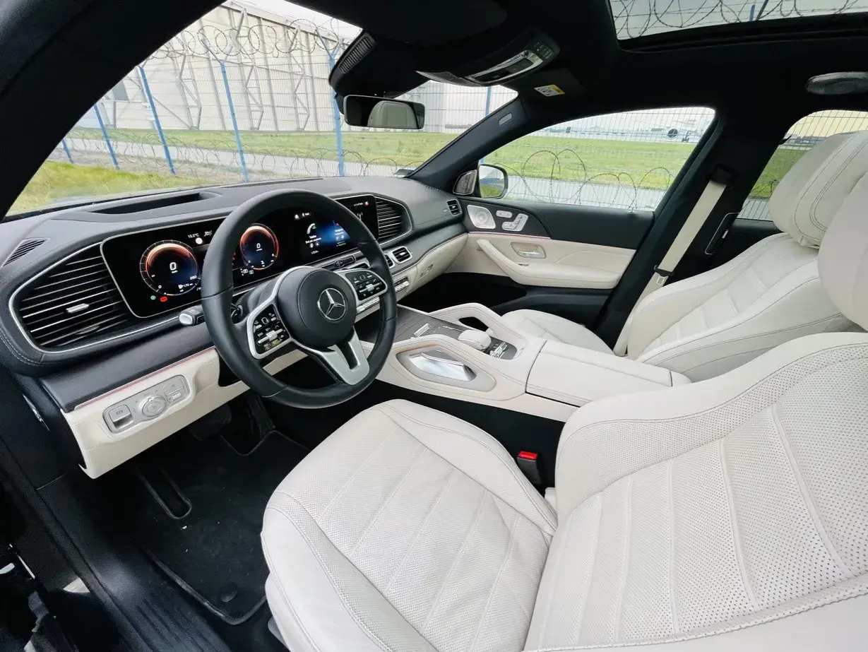 Wnętrze luksusowego Mercedesa GLE 400d z jasną, skórzaną tapicerką i nowoczesnym kokpitem.