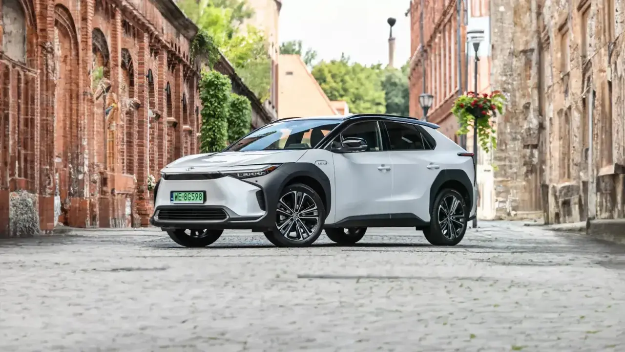Biała Toyota bZ4X na brukowanej uliczce. Sprawdź atrakcyjną toyota bz4x cena i odkryj jej możliwości.