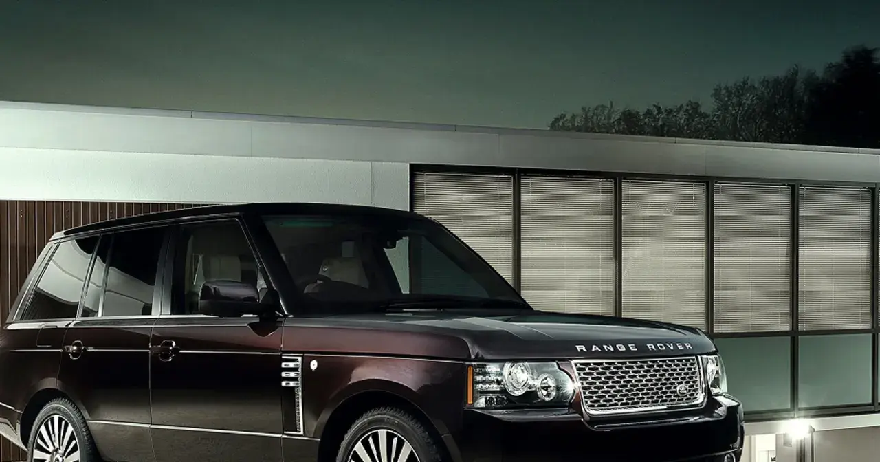 Elegancki Range Rover Autobiography w ciemnym kolorze lśni przed nowoczesnym budynkiem z przeszklonymi oknami.