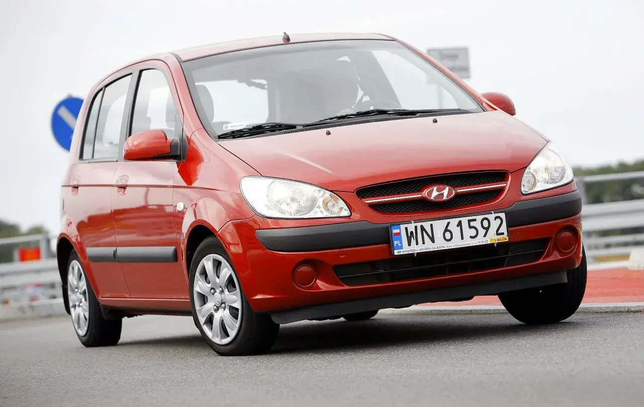 Czerwony Hyundai Getz 1.1 z polskimi tablicami WN 61592 na drodze.