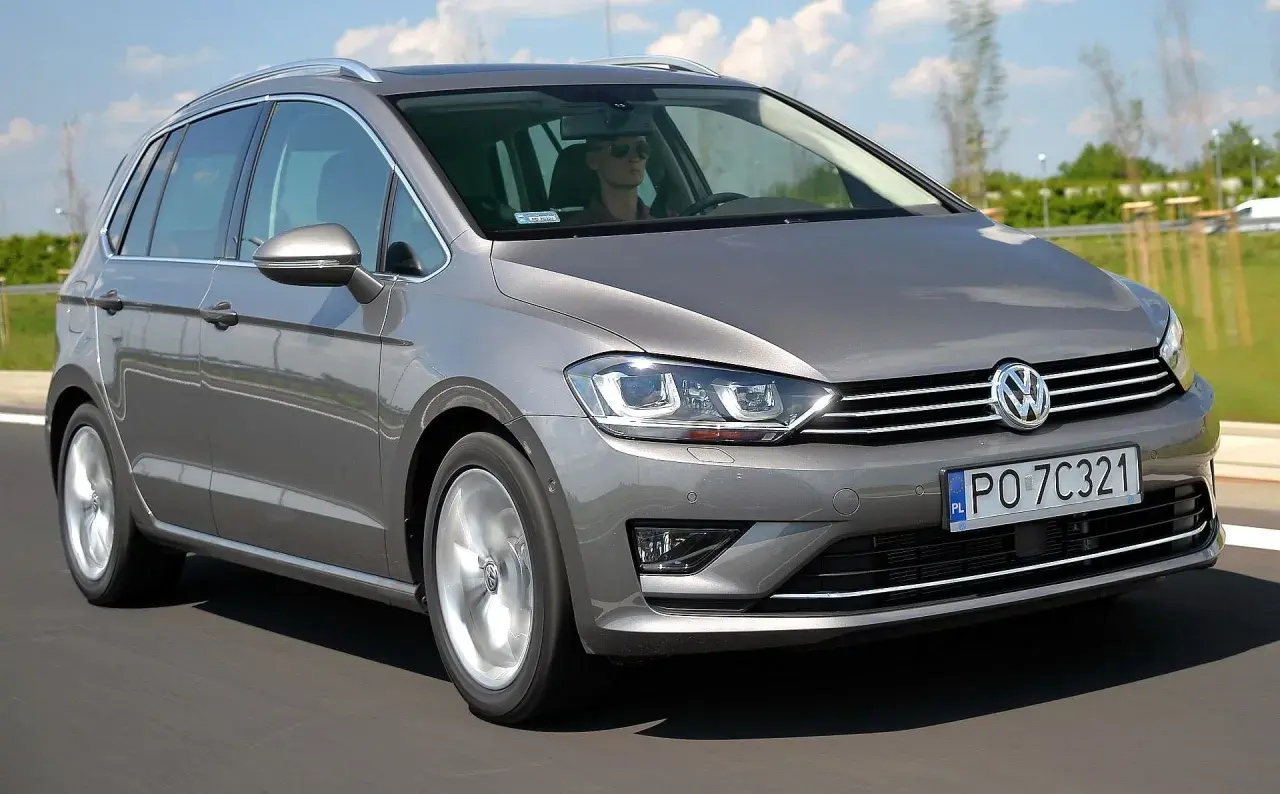 Szary Volkswagen Golf Sportsvan w ruchu drogowym. Wady tego modelu mogą obejmować ograniczoną przestrzeń bagażową w porównaniu do innych kombi.