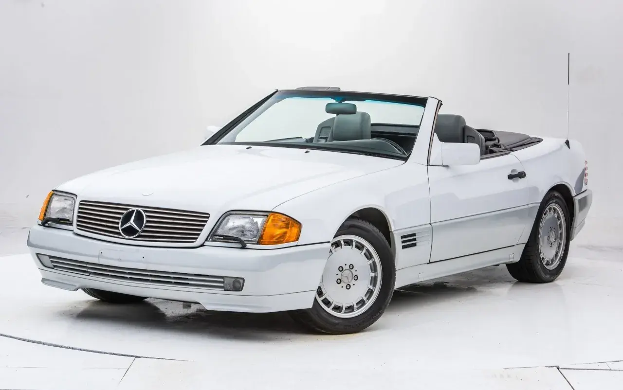 Biały kabriolet Mercedes-Benz SL500 z lat 90. z szarym wnętrzem, gotowy na letnią przejażdżkę.