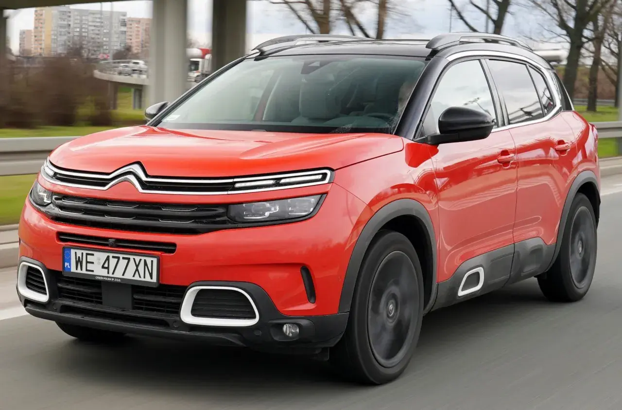 Czerwony Citroen C5 Aircross na drodze. Wiele pozytywnych citroen c5 aircross opinie potwierdza jego komfort i styl.