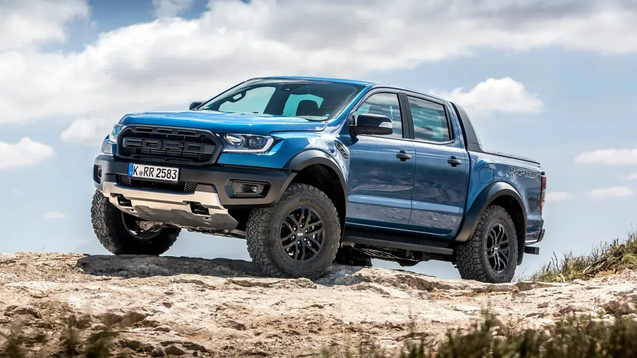 Niebieski Ford Ranger Raptor, terenowy pickup, pokonuje kamienisty szlak. Jego masywna sylwetka i opony sugerują gotowość do wyzwań, jakby był większym bratem modelu ram 2500.