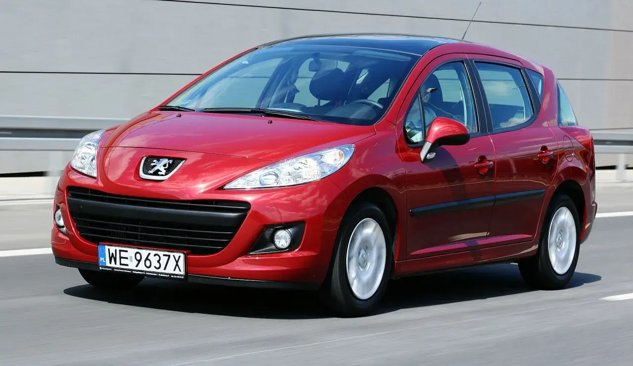 Czerwony Peugeot 207 na drodze. Wiele osób szuka peugeot 207 opinie, ten model jest świetnym wyborem.