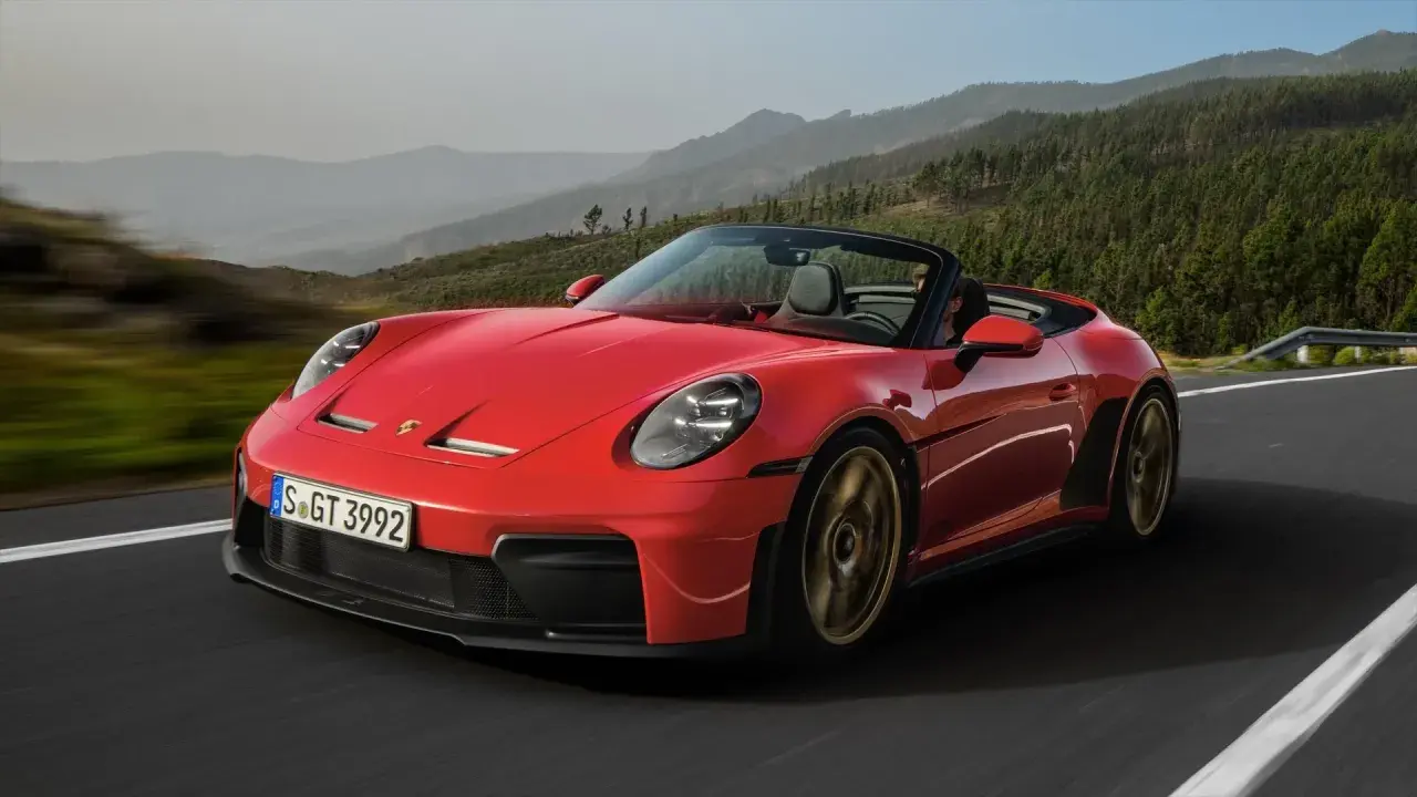 Czerwony kabriolet Porsche 911 GT3 na górskiej drodze. Sprawdź aktualną porsche 911 cena.