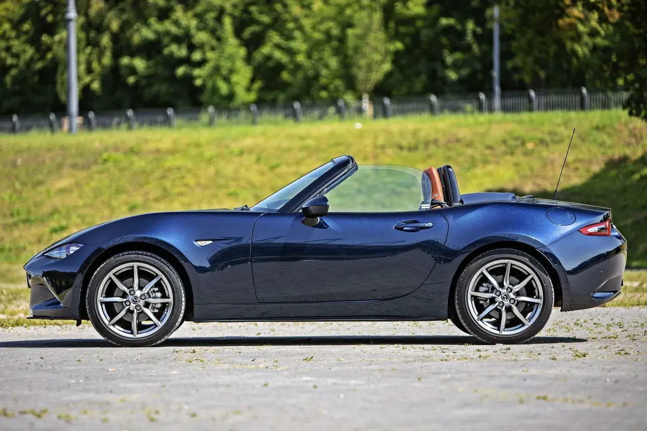 Granatowy roadster z otwartym dachem, gotowy na letnią przejażdżkę.