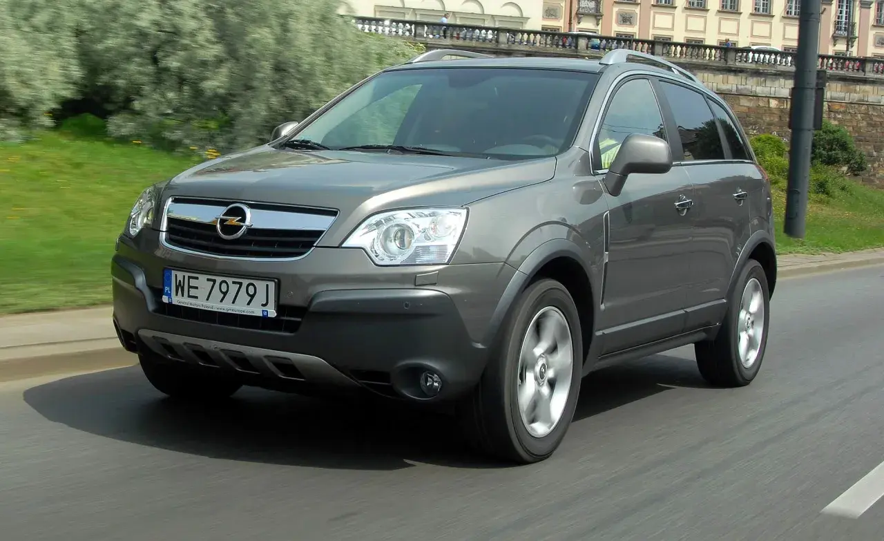 Szary Opel Antara 2.0 CDTI w ruchu miejskim, z widocznym numerem rejestracyjnym WE 7979 J.