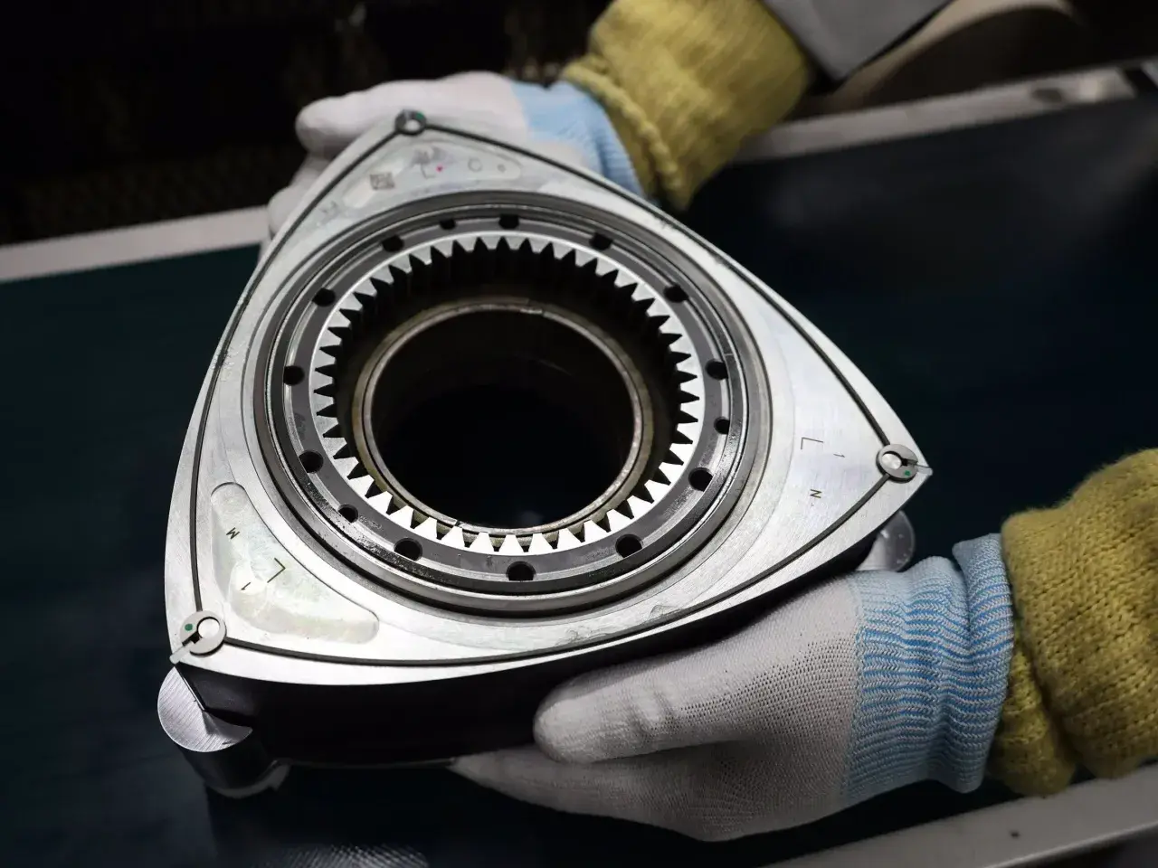 Rotor silnika Wankla, serce legendarnej Mazdy RX-3, w rękach mechanika.