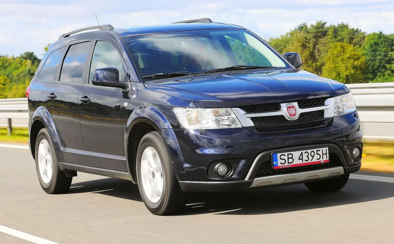 Ciemnoniebieski Fiat Freemont w ruchu drogowym. Wiele osób szuka fiat freemont opinie przed zakupem.