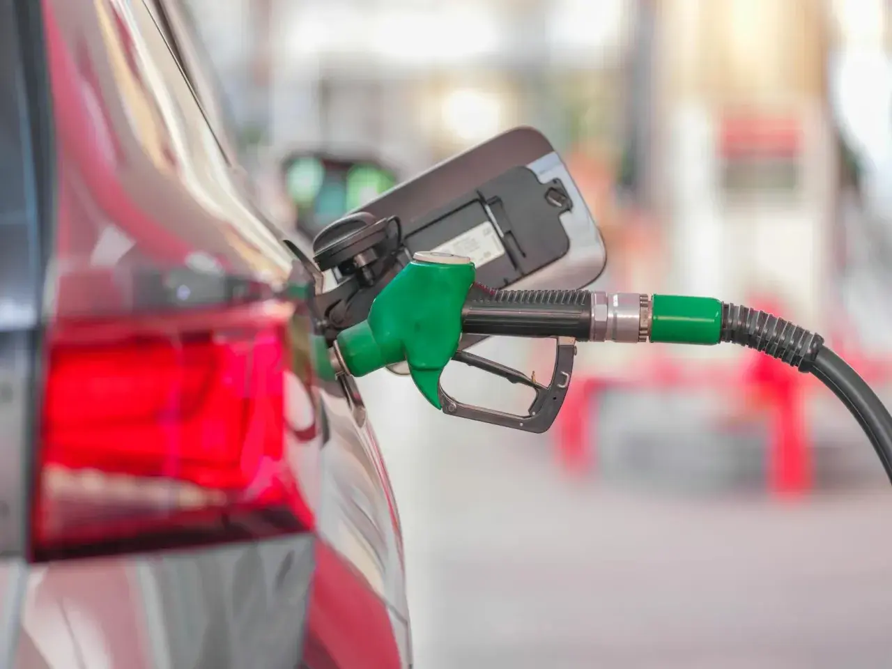 Tankowanie mojego Kia Ceed 1.6 benzyna. Zielona dysza dystrybutora paliwa wlewa benzynę do baku.