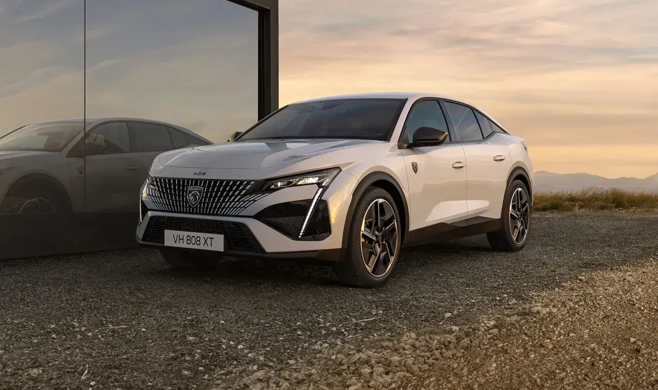 Nowy Peugeot 408 w kolorze białym, z charakterystycznym grillem i nowoczesnymi światłami. Sprawdź jego atrakcyjną peugeot 408 cenę.