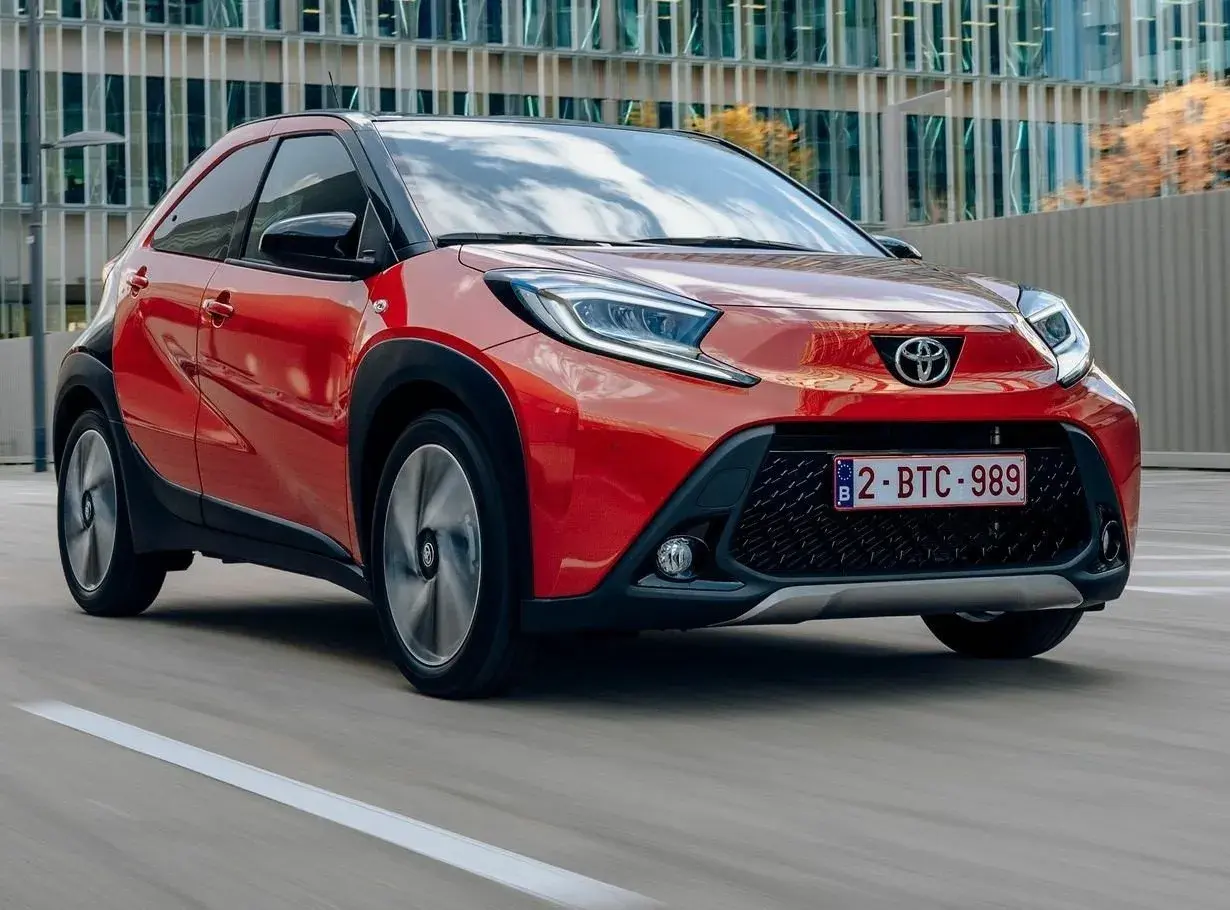 Czerwony Toyota Aygo w ruchu miejskim. Wiele osób szuka toyota aygo opinie, by poznać ten model.