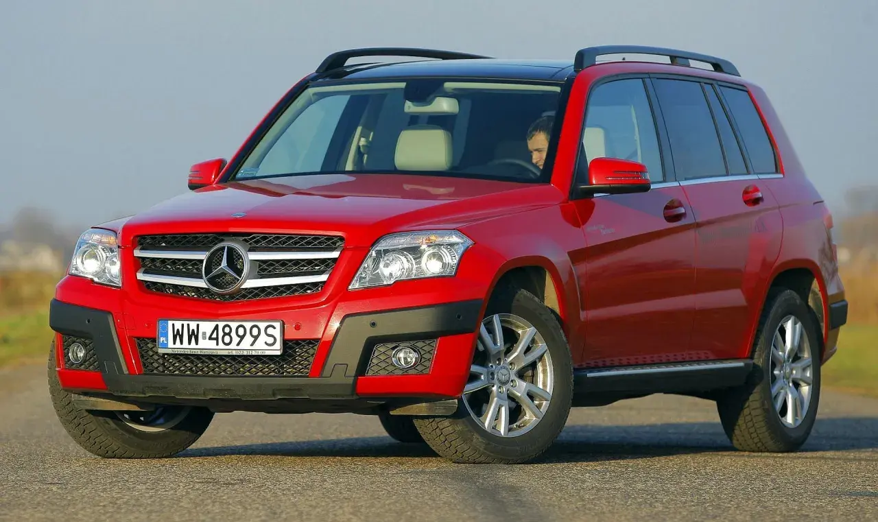 Czerwony Mercedes GLK na drodze. Kierowca w środku. Wiele osób szuka mercedes glk opinie przed zakupem.