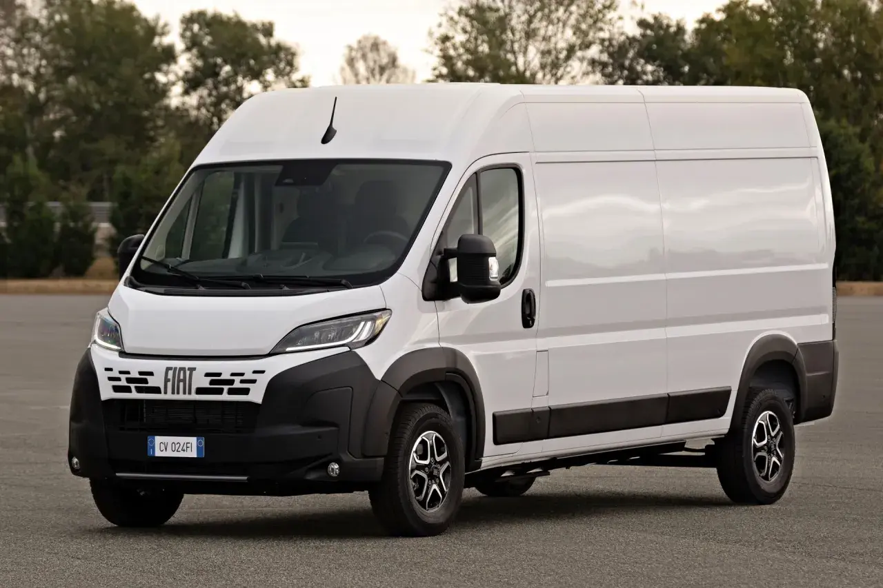 Biały Fiat Ducato Maxi, gotowy do transportu towarów, stoi na tle drzew.