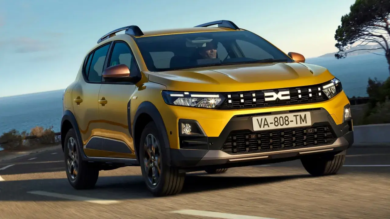 Żółty Dacia Sandero na drodze nad morzem. Sprawdź atrakcyjną dacia sandero cena!