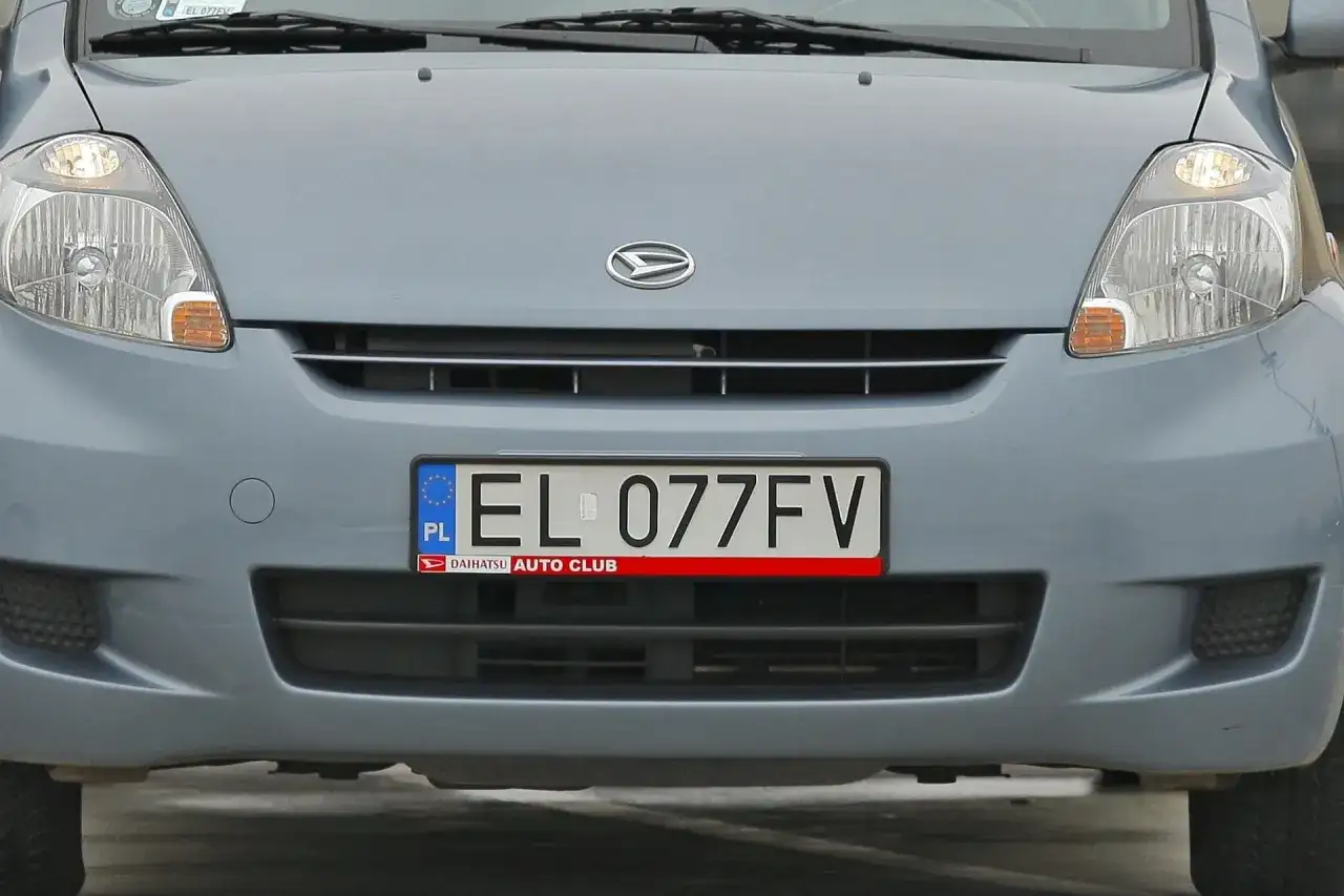 Przód błękitnego samochodu z widocznym logo Daihatsu i tablicą rejestracyjną EL 077FV.