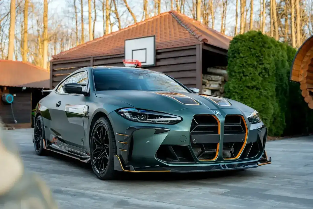 Sportowy BMW M4 w zielonym matowym kolorze z pomarańczowymi akcentami. Sprawdź aktualną bmw m4 cena!