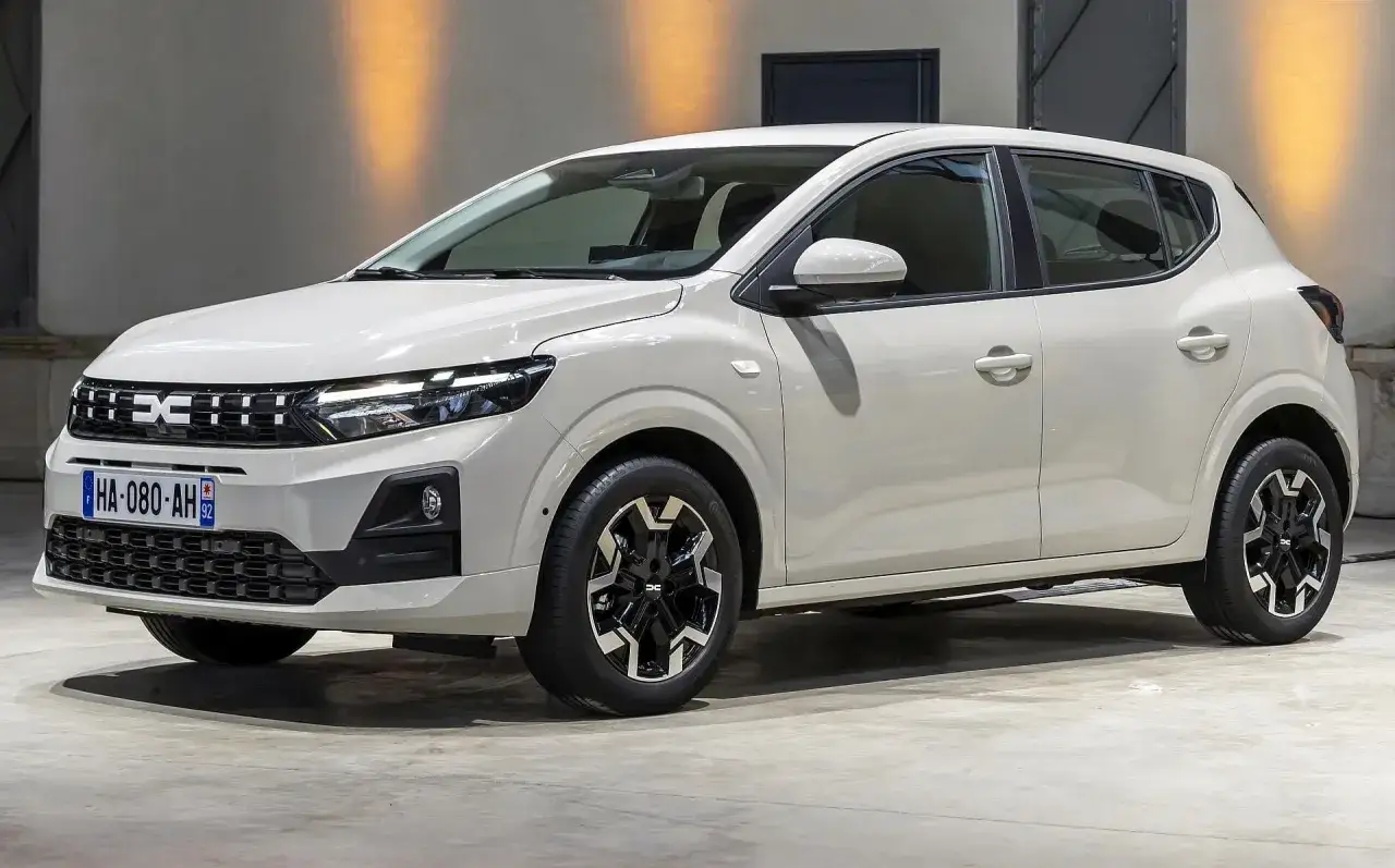Biały Dacia Sandero na tle hali wystawowej. Sprawdź atrakcyjną dacia sandero cena i wyposażenie.