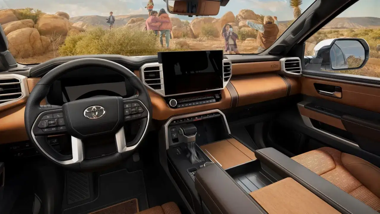 Wnętrze Toyoty Sequoia z brązową tapicerką i drewnianymi akcentami. Rodzina cieszy się krajobrazem na zewnątrz.