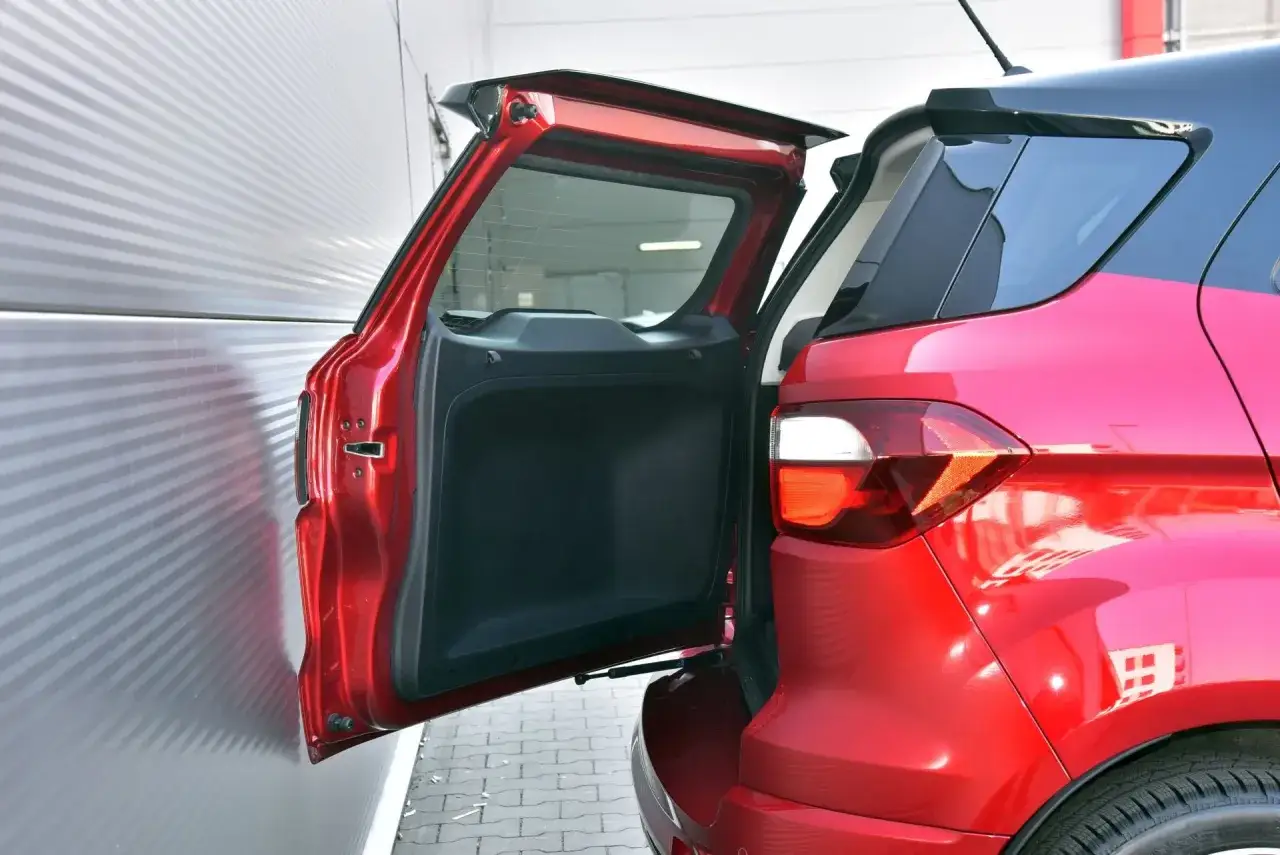 Czerwony Ford Ecosport z otwartą klapą bagażnika. Wiele osób szuka ford ecosport opinie, by sprawdzić jego funkcjonalność.