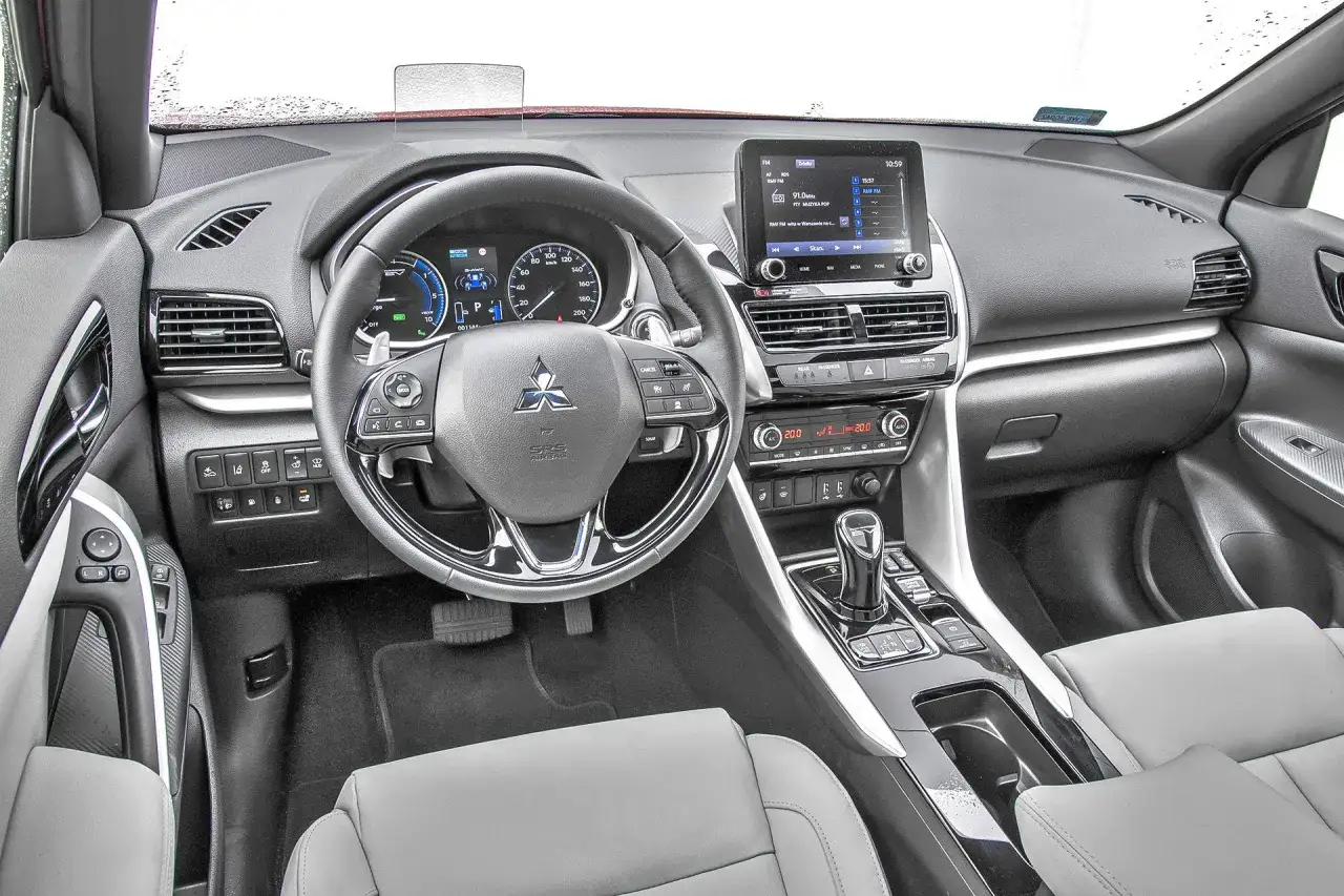 Wnętrze Mitsubishi Eclipse Cross: kierownica, ekran multimediów i konsola środkowa. Wiele osób szuka mitsubishi eclipse cross opinie, by poznać ten model.
