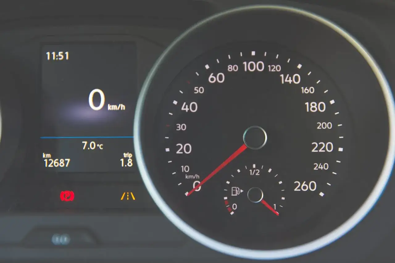 Zegar pokazuje 11:51, prędkość 0 km/h, temperaturę 7.0°C. Wskaźnik paliwa jest bliski zera, co sugeruje zbliżające się spalanie paliwa.