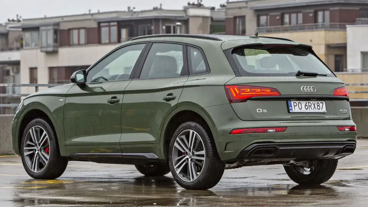 Zielony Audi Q5 na mokrym parkingu. Sprawdź aktualną audi q5 cena i dostępne konfiguracje.