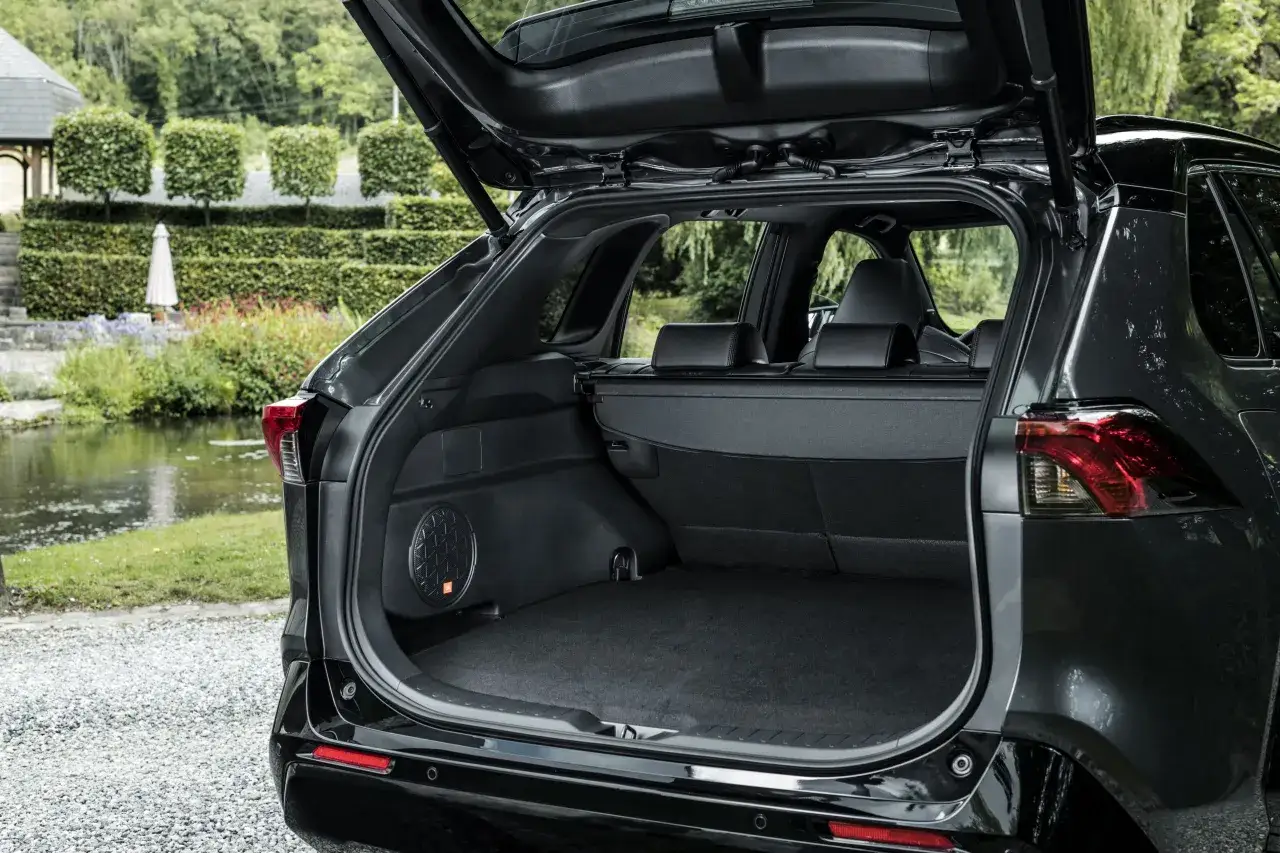 Bagażnik czarnego Toyota RAV4 2020 z otwartą klapą. Widać subwoofer JBL.