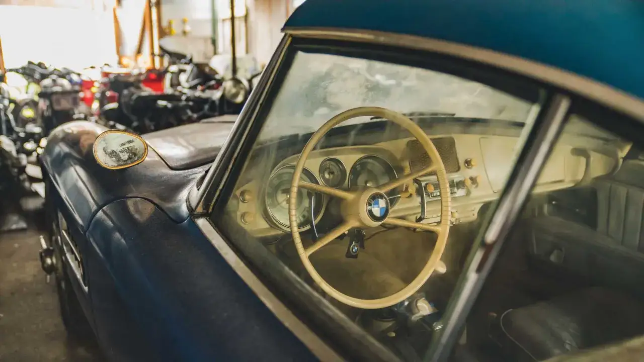 Wnętrze klasycznego BMW 507 z kremową kierownicą i deską rozdzielczą.