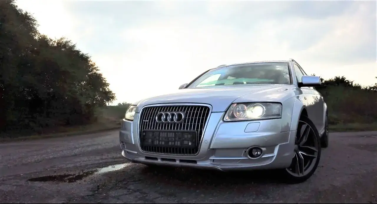 Srebrny Audi A6 C6 3.0 TDI Quattro S-line na tle drzew i nieba.