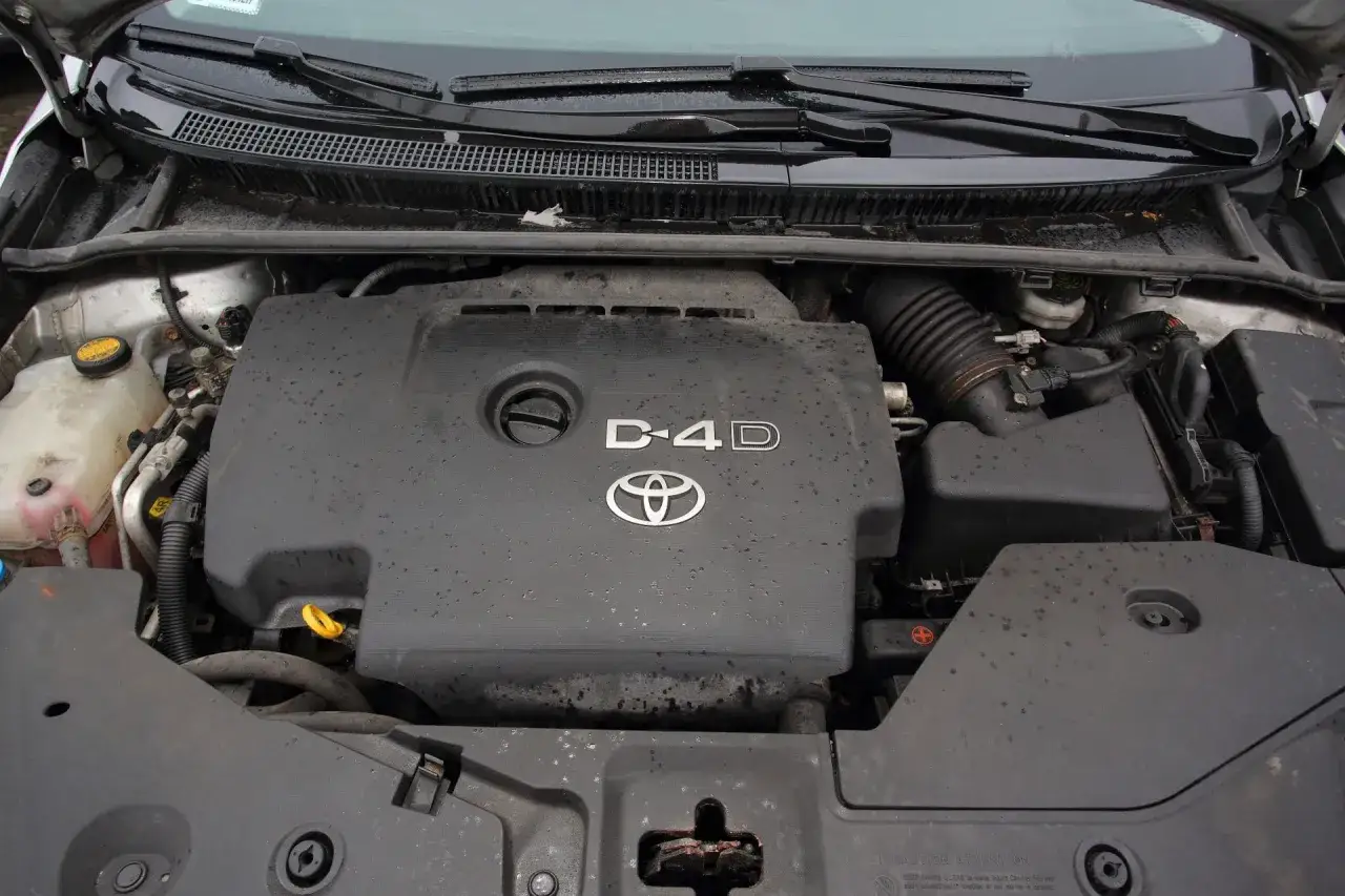 Silnik Toyota Avensis 2.0 D4D, widok z góry. Pokrywa silnika z logo Toyoty i oznaczeniem D-4D.