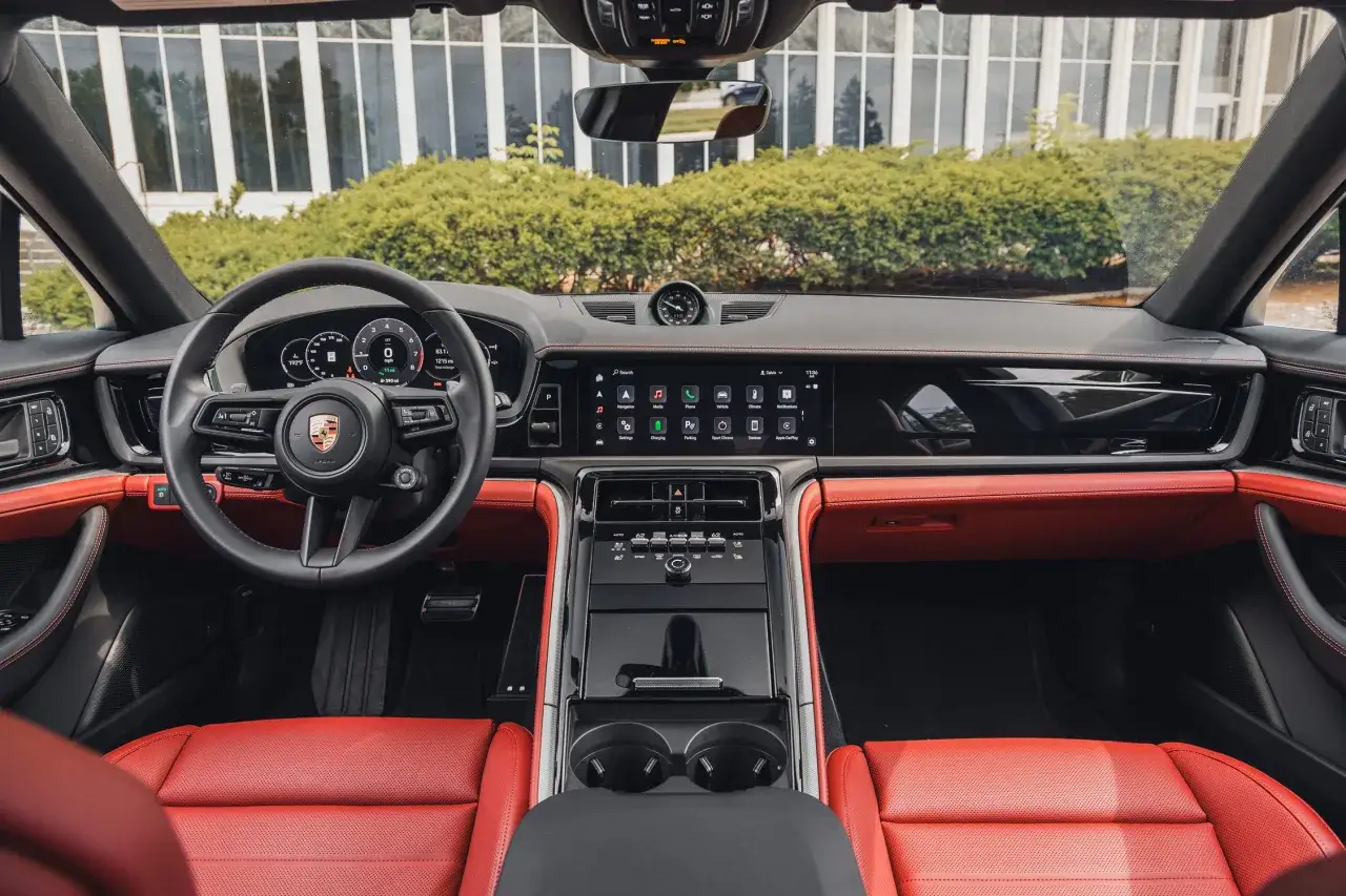 Wnętrze Porsche Panamera z czerwonymi skórzanymi fotelami i nowoczesnym panelem sterowania.