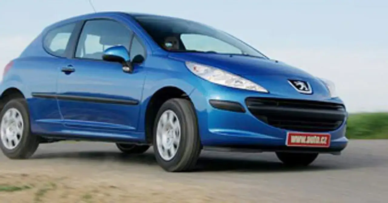 Niebieski Peugeot 207 1.4 benzyna w ruchu, z widocznym logo marki i tabliczką z adresem strony internetowej.